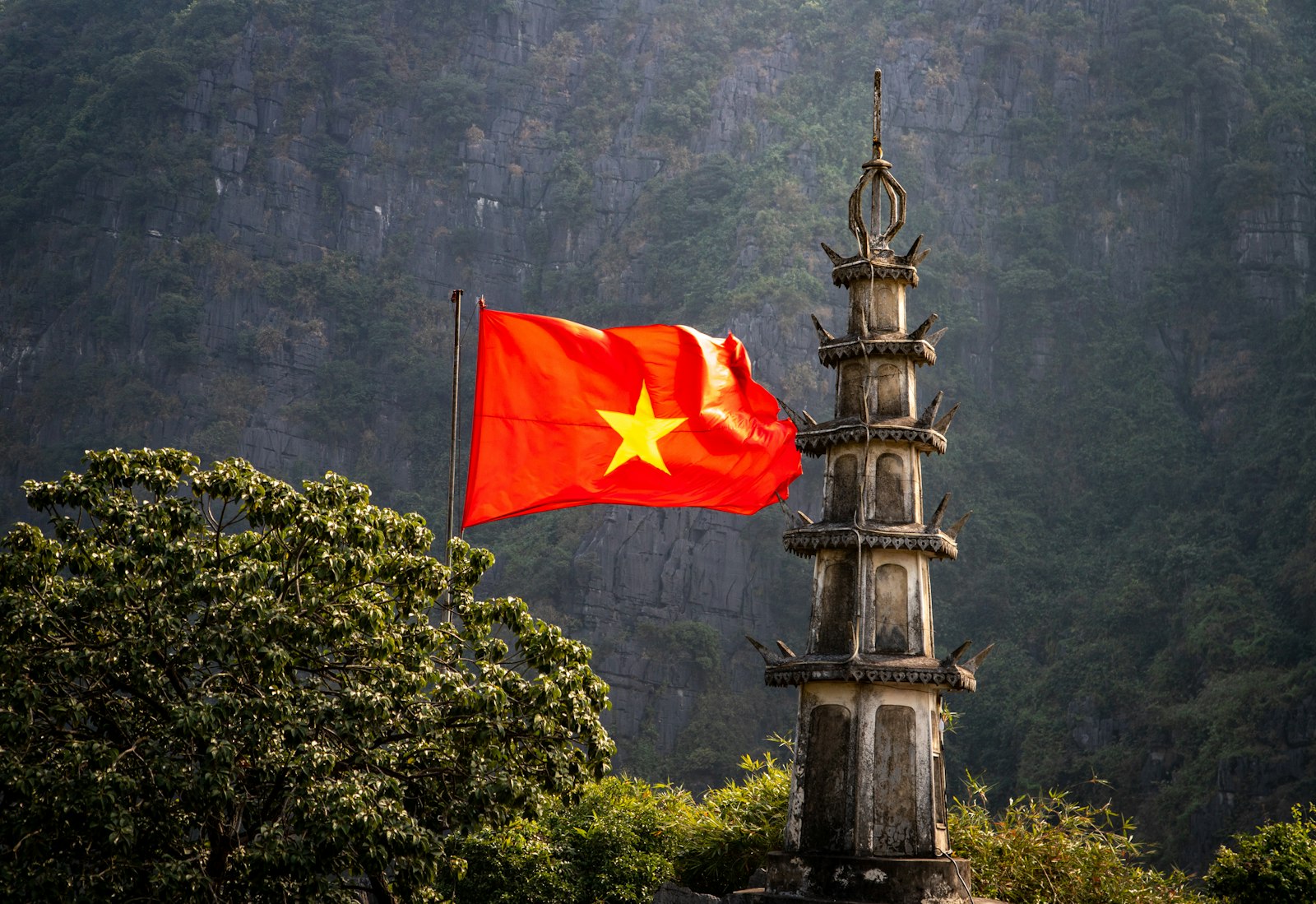 A red and yellow flag flying in front of a mountain
