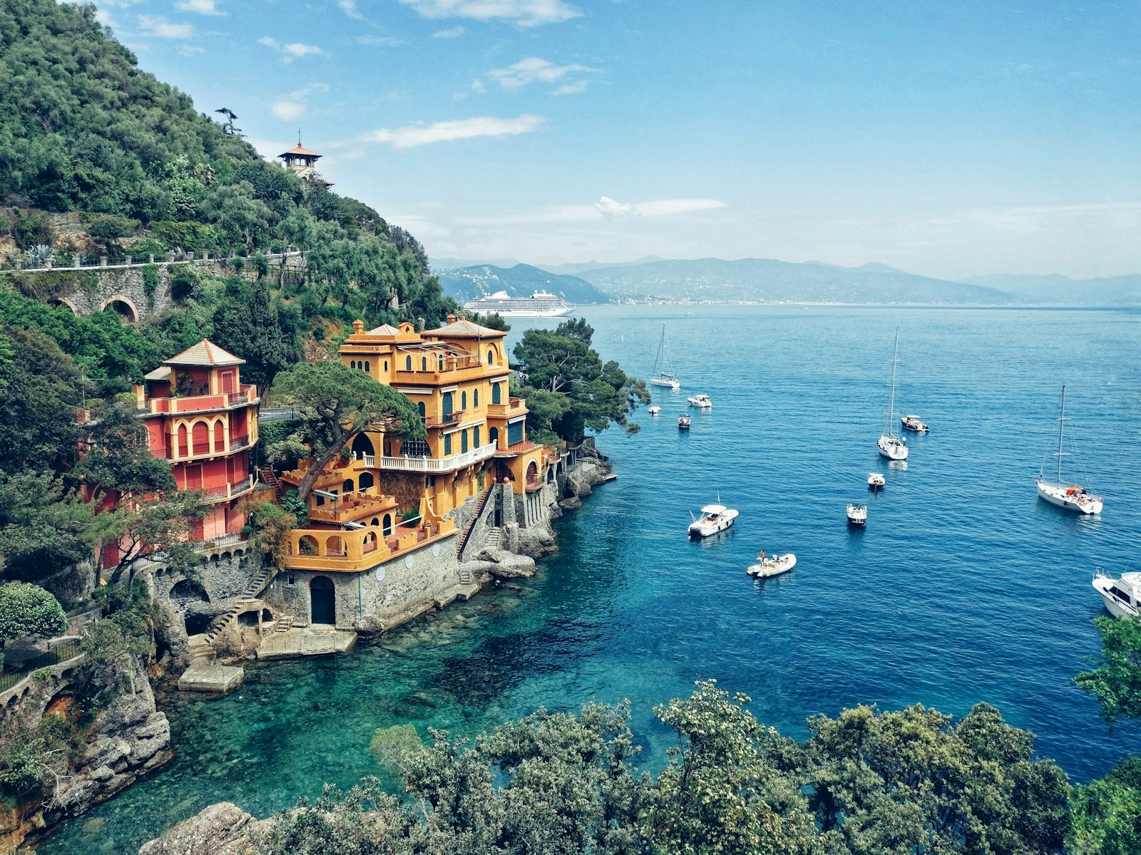 Colorful villas on rocky cliffs overlooking the blue sea in Portofino, Italy
